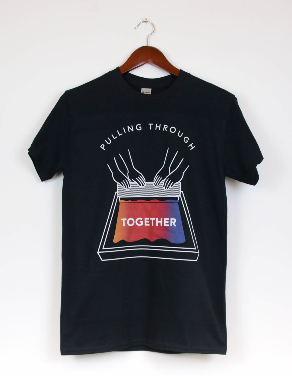 Black crew-neck t-shirt with graphic illustration of two pairs of hands pulling multicolour ink on a screen with a squeegee. The words in the graphic read "Pulling Through Together". The words ‘Pulling Through’ arch above the hands, and the word ‘Together’ is written on the silkscreen.