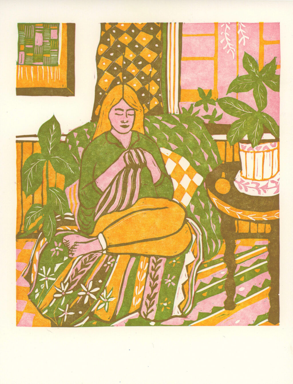 Print by Morgan Pinnock. A linocut in yellow, pink, green, and brown, depicting a figure with long golden hair is sewing a striped fabric, while sitting on a plush chair, in a room filled with brightly patterned cloth, and green plants.