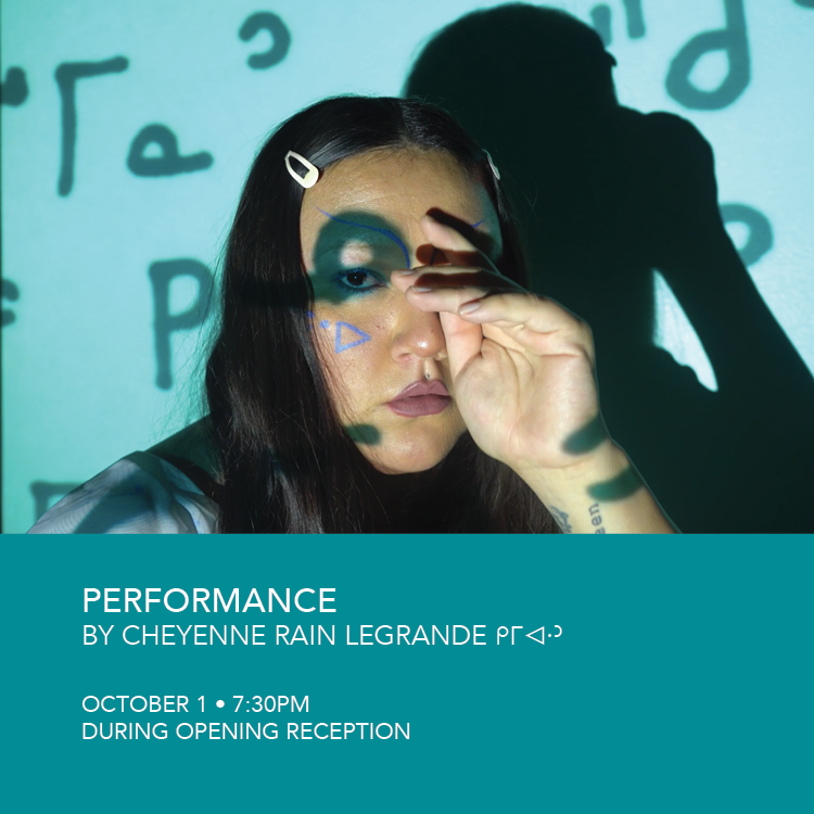  a graphic with an image on top and text on the bottom. The text reads "Performance , by Cheyenne Rain LeGrande ᑭᒥᐊᐧᐣ , October 1 • 7:30PM during opening reception". The image is a still from the performance "Cahkipêhikan". An Indigenous woman stares at the camera wearing two pink clips in her hair. She has blue Nehiyaw (Cree) syllabics drawn on her face. Projected on her face and the wall is Nehiyaw Syllabics meaning: Mosum and Kokum.