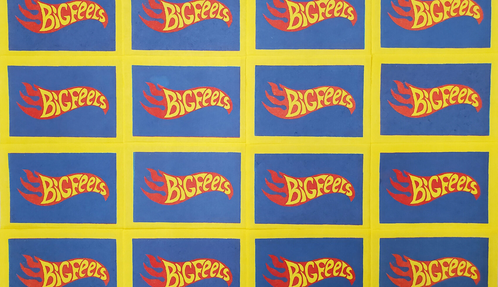 This image depicts a grid of identical prints on yellow paper. Each print features a blue rectangle containing a stylized red flame. The flame is emblazoned with yellow text that reads “Big Feels”. The overall design of the prints is strongly reminiscent of the Hot Wheels logo.
